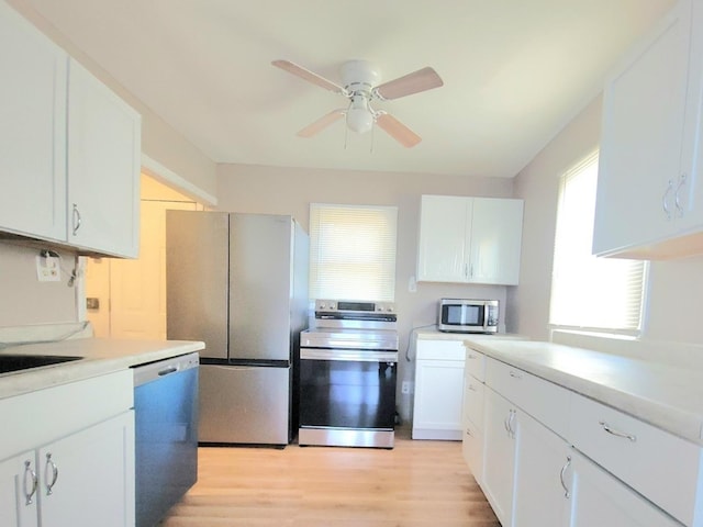1357 Morgan St, Joliet, IL 60436 - kitchen featuring appliances with stainless steel finishes, a ceiling fan, light wood-style floors, white cabinetry, and light countertops