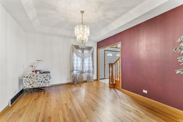 1007 Wildwood Ln, Mount Prospect, IL 60056 - empty room featuring a chandelier, wood finished floors, a tray ceiling, and stairs