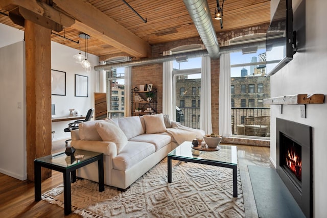550 N Kingsbury St Unit 515, Chicago, IL 60654 - living room with wood finished floors, a warm lit fireplace, and a wood ceiling with exposed beams