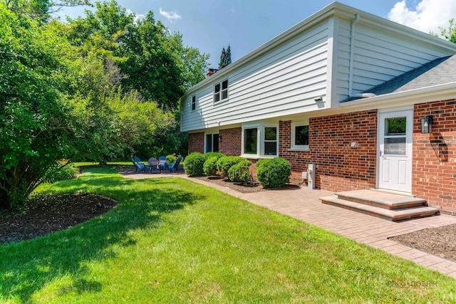 555 W Everett Rd, Lake Forest, IL 60045 - back of house with brick siding, a patio area, and a yard