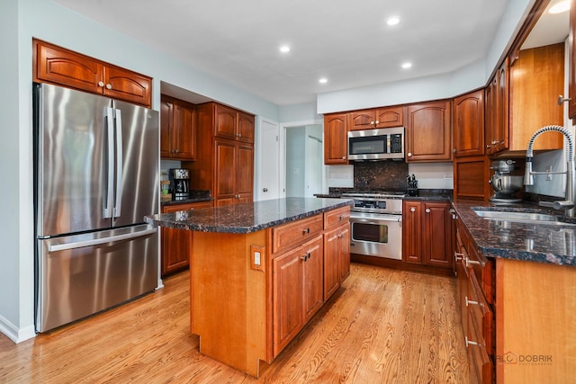 555 W Everett Rd, Lake Forest, IL 60045 - kitchen with stainless steel appliances, a center island, light wood-type flooring, dark stone counters, and recessed lighting