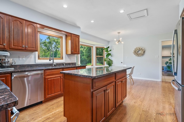 555 W Everett Rd, Lake Forest, IL 60045 - kitchen featuring appliances with stainless steel finishes, light wood finished floors, a center island, dark stone counters, and recessed lighting