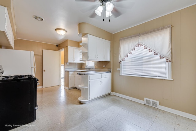 8822 S Paulina St, Chicago, IL 60620 - kitchen featuring black gas stove, open shelves, freestanding refrigerator, a ceiling fan, and white cabinetry