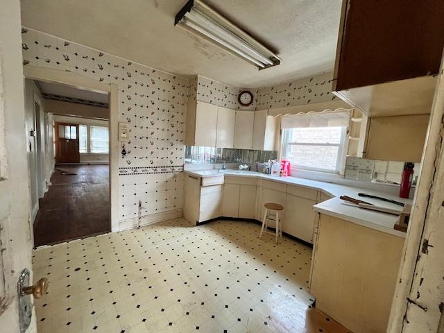 2722 Euclid Ave, Berwyn, IL 60402 - kitchen with light flooring, light countertops, and wallpapered walls