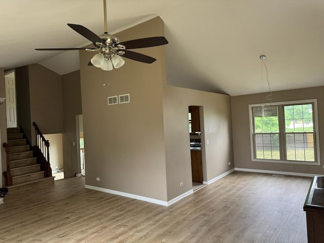 2404 Kenmore Ct, Schaumburg, IL 60193 - unfurnished living room featuring wood finished floors, a ceiling fan, stairs, and high vaulted ceiling