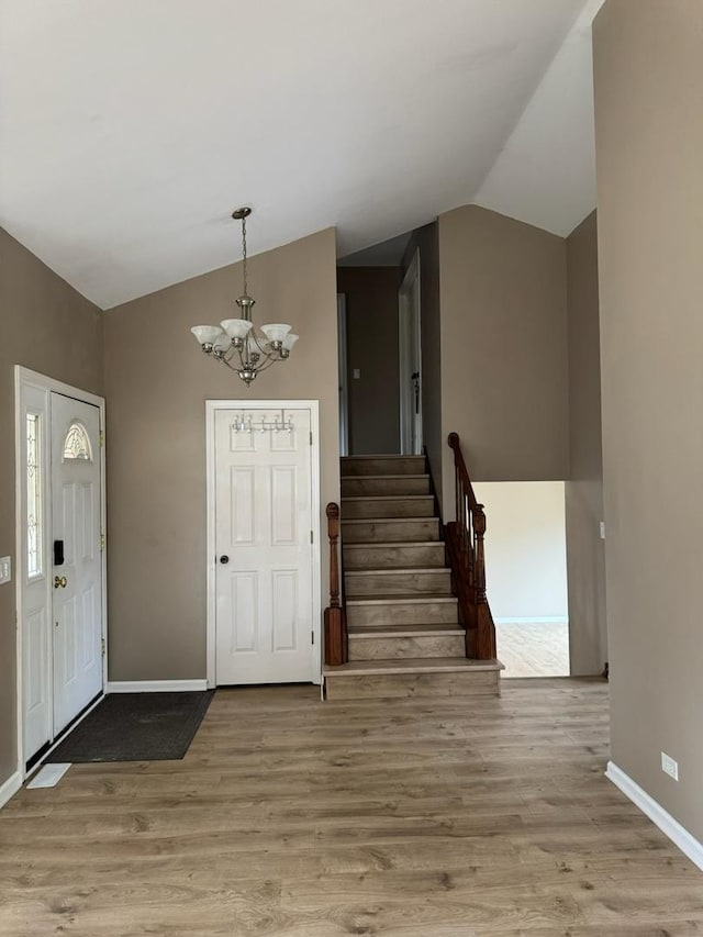 2404 Kenmore Ct, Schaumburg, IL 60193 - foyer featuring vaulted ceiling, a chandelier, wood finished floors, and stairs