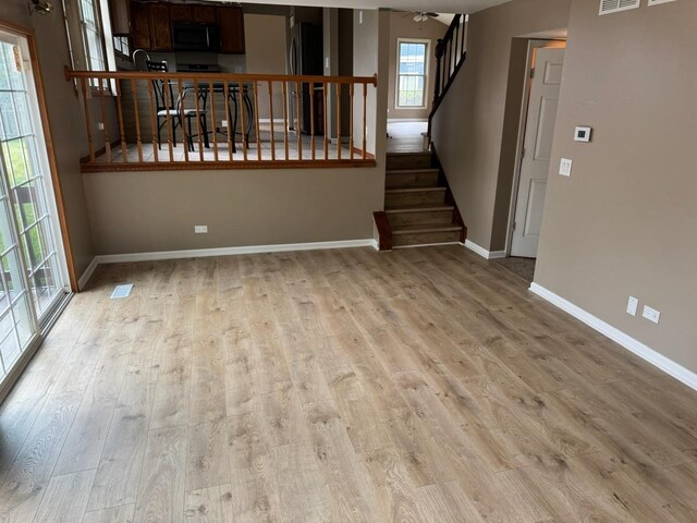 2404 Kenmore Ct, Schaumburg, IL 60193 - unfurnished living room featuring light wood-style flooring and stairway