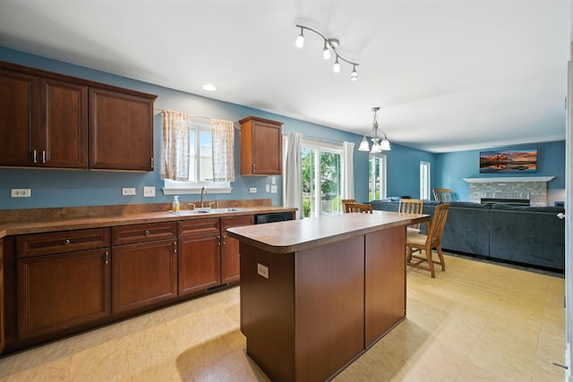 2942 Heather Ln, Montgomery, IL 60538 - kitchen with a chandelier, light floors, a fireplace, a center island, and hanging light fixtures