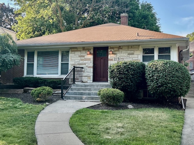 219 Spring Ave, Naperville, IL 60540 - view of front of home with a chimney, stone siding, a front yard, and a shingled roof