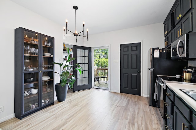 443 W Water St, Kankakee, IL 60901 - kitchen with stainless steel microwave, a chandelier, light wood-style floors, glass insert cabinets, and decorative light fixtures