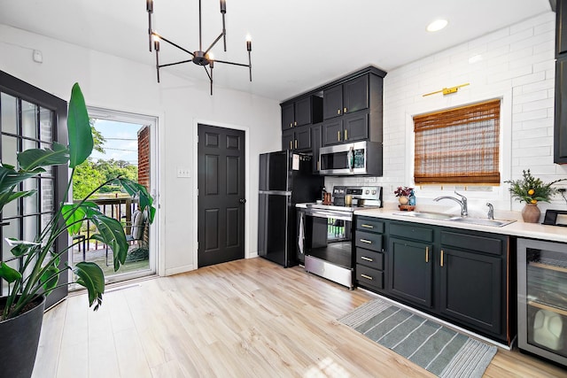 443 W Water St, Kankakee, IL 60901 - kitchen with appliances with stainless steel finishes, beverage cooler, a chandelier, light countertops, and light wood-style floors