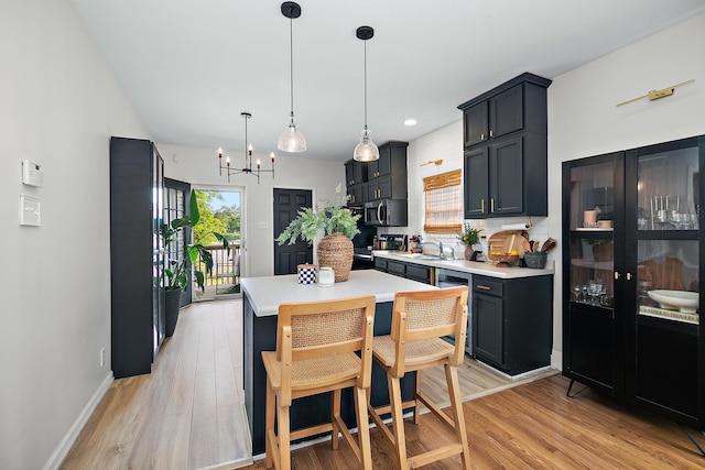 443 W Water St, Kankakee, IL 60901 - kitchen with stainless steel microwave, a chandelier, light countertops, range, and light wood-style floors
