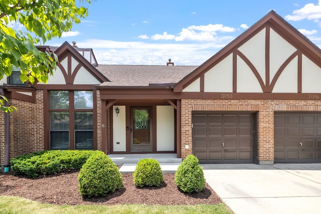 3050 Ashton Ct, Westchester, IL 60154 - tudor home featuring stucco siding, brick siding, roof with shingles, concrete driveway, and a garage