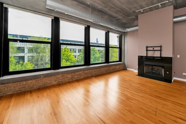 1151 W 15th St Unit 336, Chicago, IL 60608 - unfurnished living room with wood finished floors, rail lighting, and a fireplace with flush hearth