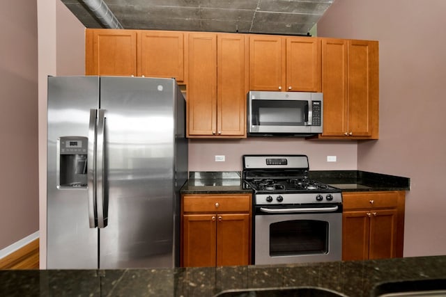 1151 W 15th St Unit 336, Chicago, IL 60608 - kitchen with stainless steel appliances, dark stone counters, wood finished floors, and brown cabinetry