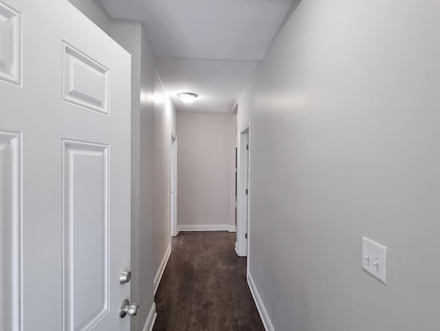 hall with baseboards and wood finished floors