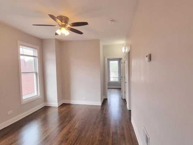 spare room with dark wood finished floors, ceiling fan, and a smoke detector