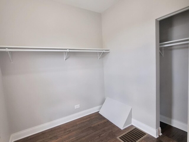 walk in closet with wood finished floors