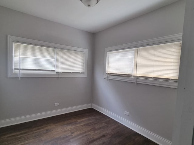 unfurnished room featuring dark wood-style floors and baseboards