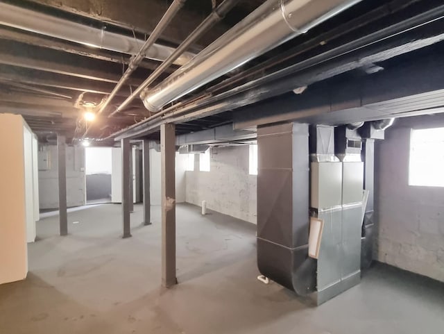 basement featuring heating unit and electric panel