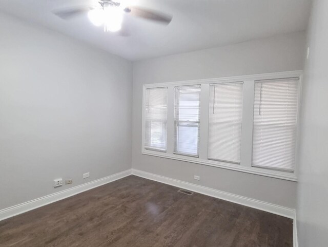 empty room with dark wood-type flooring and a ceiling fan