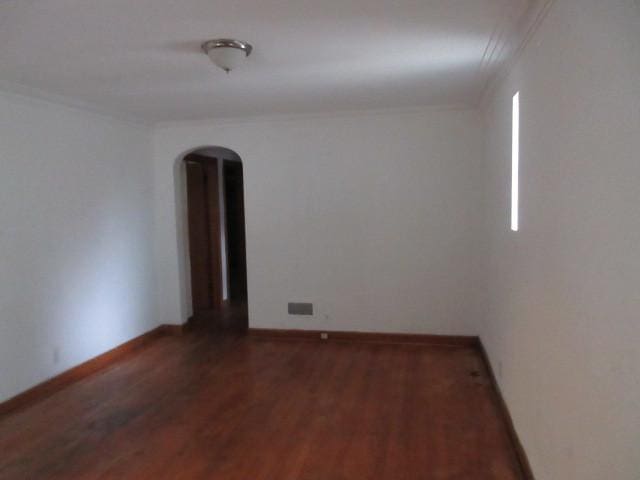 7700 S Ada St, Chicago, IL 60620 - spare room featuring arched walkways, wood finished floors, and ornamental molding