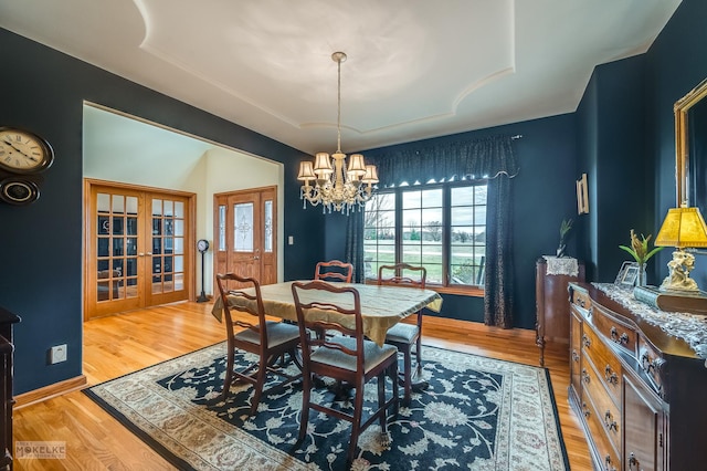 9299 Lee Hill Rd, Newark, IL 60541 - dining area with french doors, a chandelier, a tray ceiling, and light wood-style flooring