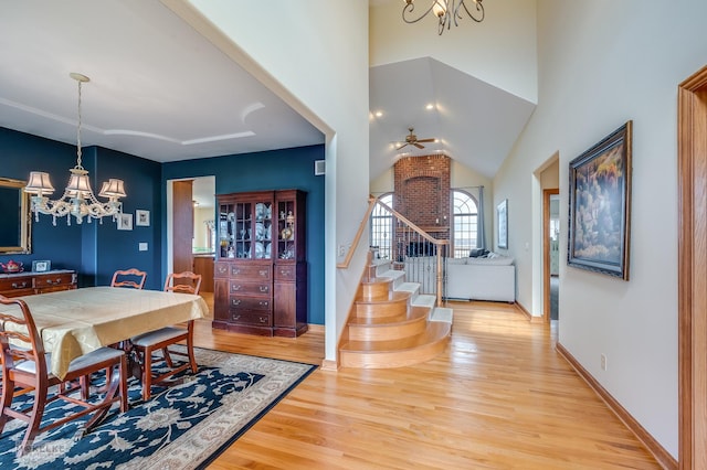9299 Lee Hill Rd, Newark, IL 60541 - dining space with a chandelier, light wood-style floors, stairs, a ceiling fan, and lofted ceiling