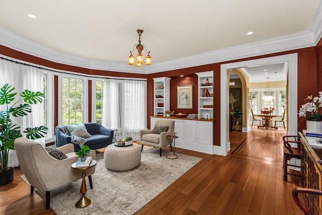 2423 Harrison St, Evanston, IL 60201 - living area with a chandelier, hardwood / wood-style flooring, ornamental molding, and arched walkways