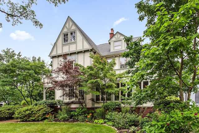 2423 Harrison St, Evanston, IL 60201 - view of front of property featuring stucco siding, a chimney, a front lawn, and roof with shingles