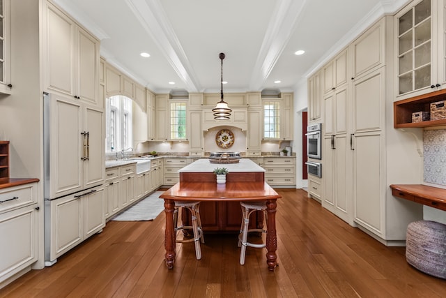 2423 Harrison St, Evanston, IL 60201 - kitchen with a warming drawer, cream cabinetry, a center island, beamed ceiling, and ornamental molding