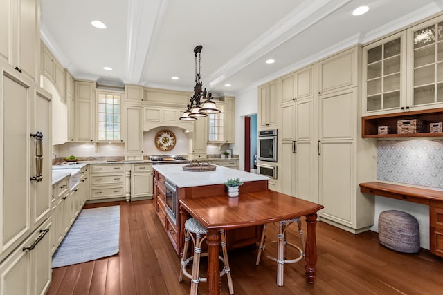 2423 Harrison St, Evanston, IL 60201 - kitchen with cream cabinets, dark wood-type flooring, appliances with stainless steel finishes, a kitchen island, and beam ceiling