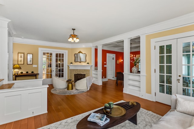 2423 Harrison St, Evanston, IL 60201 - living area featuring french doors, crown molding, wood-type flooring, a high end fireplace, and decorative columns