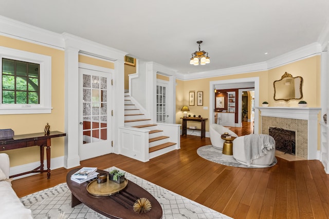 2423 Harrison St, Evanston, IL 60201 - living room featuring wood-type flooring, ornamental molding, stairs, a chandelier, and a tiled fireplace