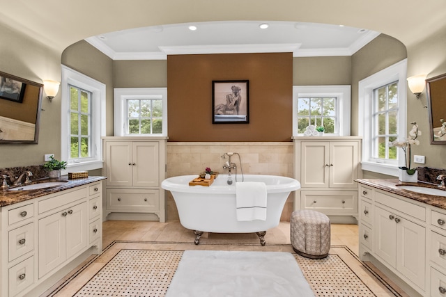 2423 Harrison St, Evanston, IL 60201 - full bath featuring ornamental molding, two vanities, healthy amount of natural light, a freestanding tub, and a wainscoted wall