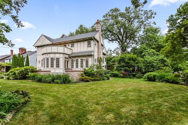 2423 Harrison St, Evanston, IL 60201 - rear view of property with a balcony, board and batten siding, a chimney, a lawn, and french doors