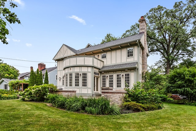 2423 Harrison St, Evanston, IL 60201 - back of property featuring a balcony, a chimney, a yard, and roof with shingles