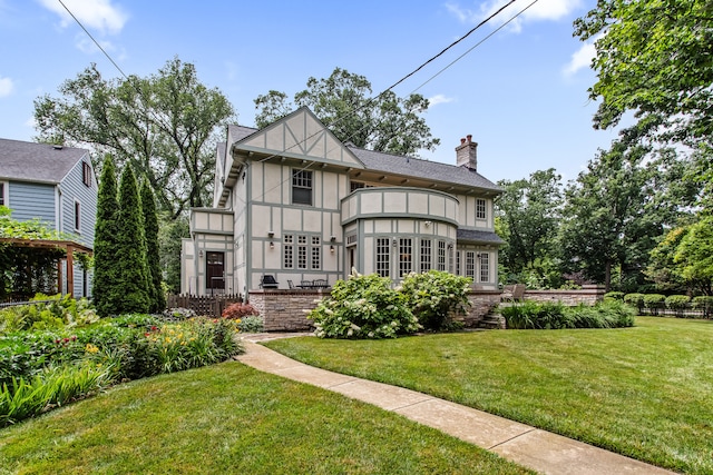 2423 Harrison St, Evanston, IL 60201 - rear view of house featuring stucco siding, a chimney, a lawn, and a balcony