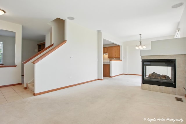 509 Legend Ln, Mchenry, IL 60050 - unfurnished living room with light colored carpet, a chandelier, stairway, and a tile fireplace