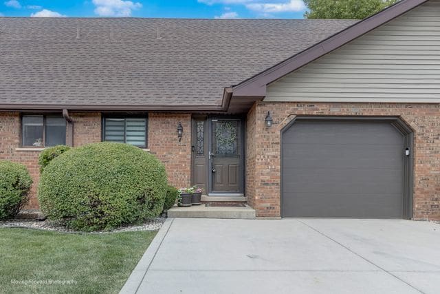 1906 Heatherway Ln Unit 7, New Lenox, IL 60451 - view of front of home with an attached garage, brick siding, driveway, and a shingled roof