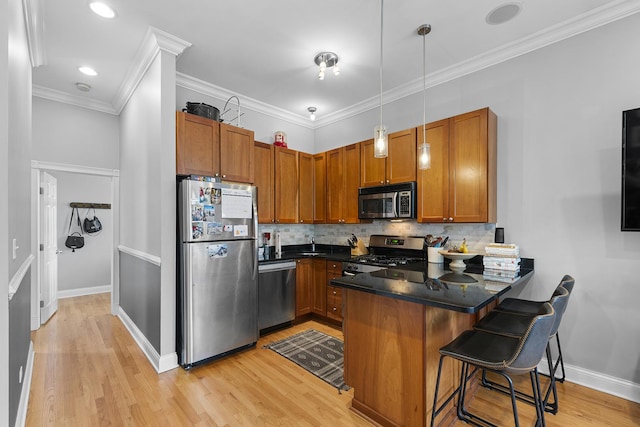 1849 W Superior St Unit 3, Chicago, IL 60622 - kitchen with appliances with stainless steel finishes, a peninsula, dark countertops, brown cabinets, and light wood-style flooring