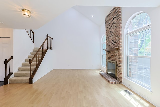 1521 Whitman Ct, Schaumburg, IL 60173 - unfurnished living room featuring light wood finished floors, stairway, high vaulted ceiling, and a fireplace