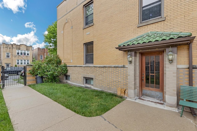 5609 N Mango Ave Unit 1W, Chicago, IL 60646 - doorway to property with a gate, brick siding, and a tile roof