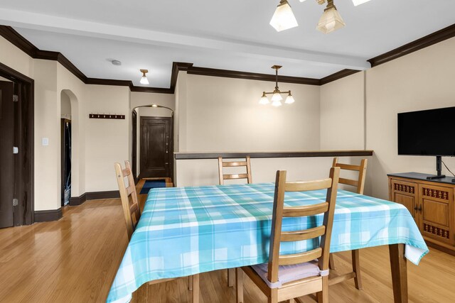 5609 N Mango Ave Unit 1W, Chicago, IL 60646 - dining area featuring ornamental molding, wood finished floors, arched walkways, and a chandelier