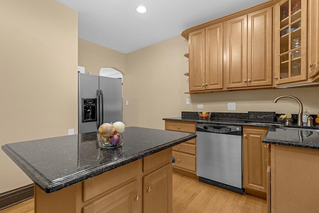 5609 N Mango Ave Unit 1W, Chicago, IL 60646 - kitchen with stainless steel appliances, arched walkways, light wood-style floors, a kitchen island, and dark stone countertops