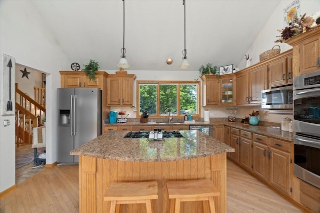 344 Prairie Ave, Winthrop Harbor, IL 60096 - kitchen with appliances with stainless steel finishes, lofted ceiling, light wood-type flooring, light stone counters, and a center island