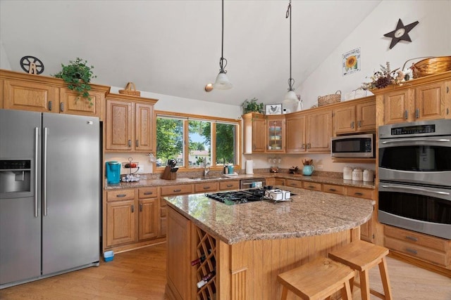 344 Prairie Ave, Winthrop Harbor, IL 60096 - kitchen with appliances with stainless steel finishes, light wood-style floors, high vaulted ceiling, light stone countertops, and a kitchen island