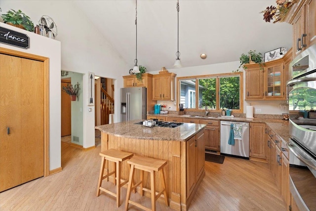 344 Prairie Ave, Winthrop Harbor, IL 60096 - kitchen with stainless steel appliances, light wood-style floors, a kitchen island, high vaulted ceiling, and light stone countertops