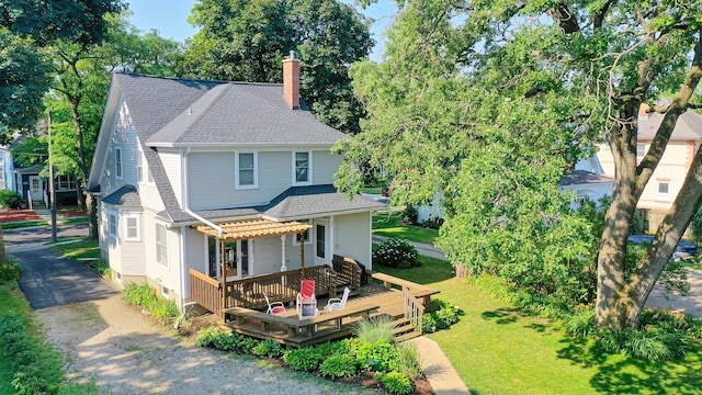 11610 2nd St, Huntley, IL 60142 - view of front of home with a chimney, a shingled roof, a deck, a pergola, and a front lawn