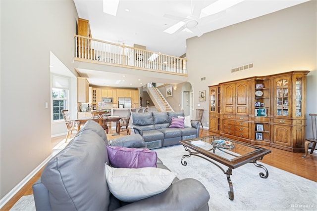18011 Breckenridge Blvd, Orland Park, IL 60467 - living area featuring stairway, light wood-type flooring, arched walkways, a ceiling fan, and a towering ceiling